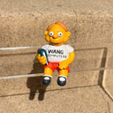 Figure of Martin Prince from The Simpsons, wearing a shirt that says "Wang Computers", sitting and holding a book at his side. 