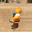 Figure of Martin Prince from The Simpsons, wearing a shirt that says "Wang Computers", sitting and holding a book at his side. 