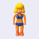 Vinyl figure of a woman with rounded blonde hair wearing a blue bikini with red sandals.