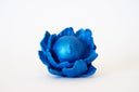 Blue flower-shaped object with a spherical center that has a calm, closed eye face.