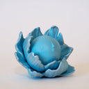 Blue flower-shaped object with a spherical center that has a calm, closed eye face.