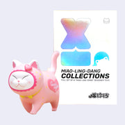 Pink cat-shaped toy with colorful packaging on a light gray background