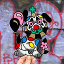 Painting on a clear die cut sheet of acrylic, of a clown dog with balloons.