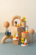 Wooden toy set with small animal figures on a checkered tablecloth