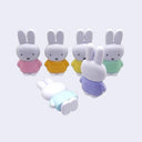 Set of six small Miffy rabbit figurines in different colored outfits on a light gray background