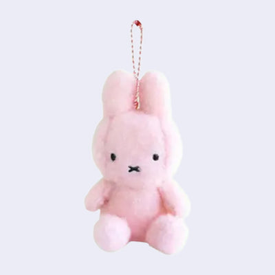 Pink plush Miffy keychain on a light purple background