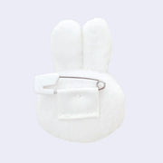 White bunny-shaped plush with ears, seen from the back with a safety pin attachment.
