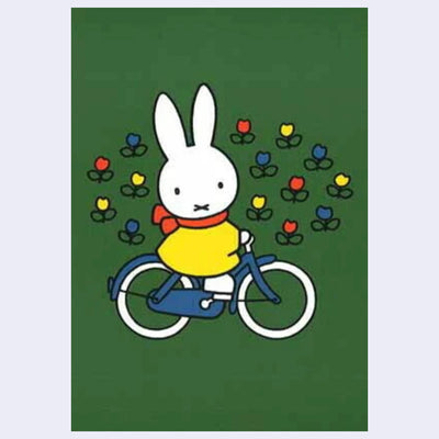 Postcard of Miffy riding a bicycle on a green background with colorful flowers.