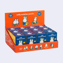 Display of Miffy surprise puzzle boxes with orange and blue packaging.