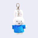 Plush keychain of Miffy, a white rabbit character, wearing a blue shirt on a light gray background