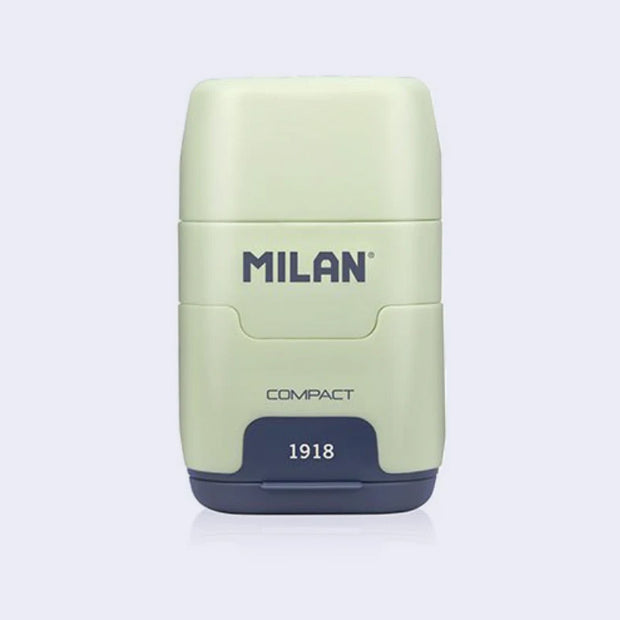 Light green and navy blue plastic case holding an eraser and a pencil sharpener within it, with 'Milan' branding on a light gray background