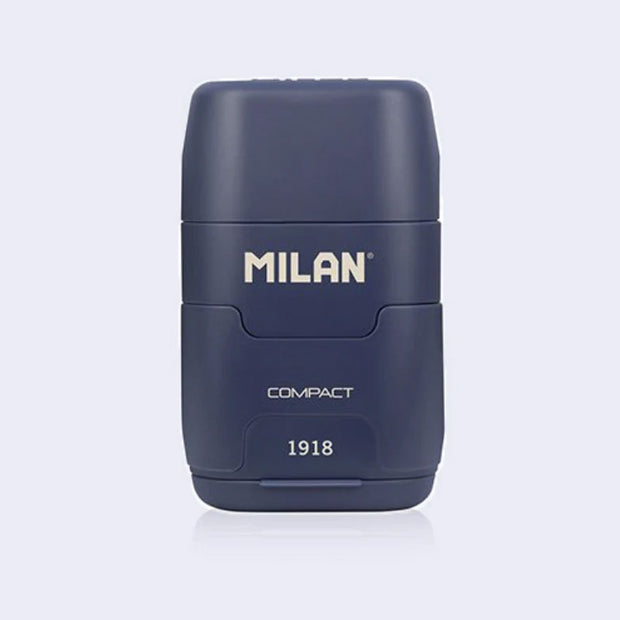 Navy blue plastic case holding an eraser and a pencil sharpener within it, with 'Milan' branding on a light gray background