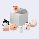 8 cat figuines posed together.