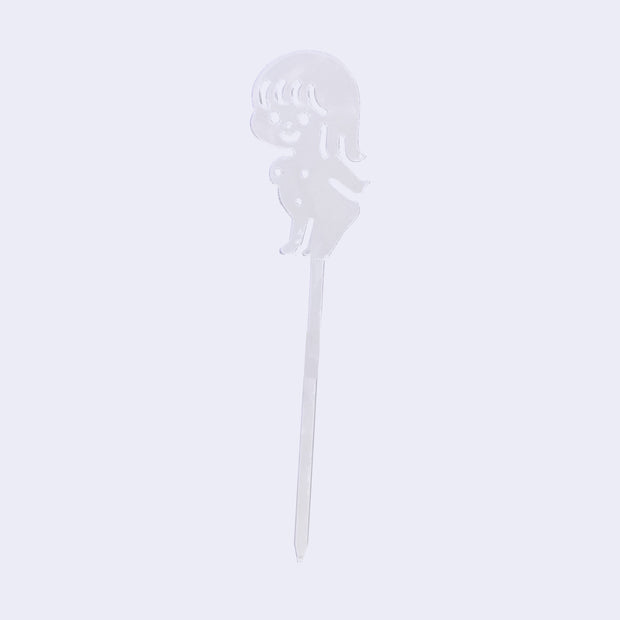 Clear acrylic die cut drink stirrer of a nude cartoon girl, standing with her arms extended behind her back.