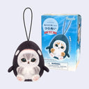Plush keychain of a penguin-like character with packaging on a light gray background