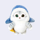 Plush doll of a gray and white cat with large teal eyes and a small mouth. It wears a blue shark costume and holds an orange squid.
