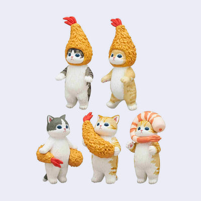 5 different cat figurines, all decorated with fried shrimps. Either as hats atop their heads or wrapped around their bodies.