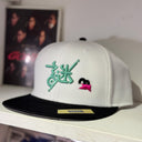 White cap with green and pink design on a shelf