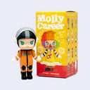 A collectible vinyl figure of Molly Career  from Pop Mart x Kenny's Work, shown standing next to its yellow and red packaging box on a light gray background.