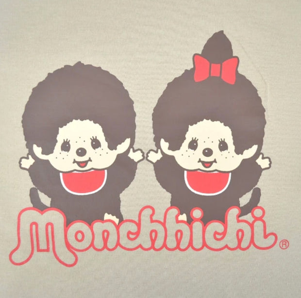 Close up of t-shirt graphic with two Monchhichi characters wearing matching red bibs and cheering with their hands up.