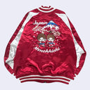 Red satin jacket with cartoon characters and 'Japan Monchhichi' text on a white background