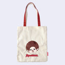 Tote bag with a cartoon monkey, Monchhichi and 'Monchhichi' branding on a light purple background
