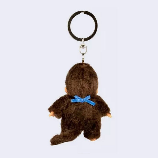 Small plush keychain of a Monchhichi doll,  fluffy monkey plush with a cute face. It wears a blue bib. Backside.