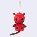 Plush Monchhichi monkey keychain wearing a red ladybug hat and blue overalls on a light gray background.