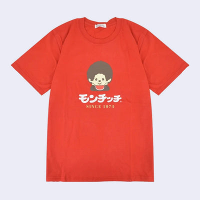 Red t-shirt with a graphic of a Monchhichi, wearing a red bib and holding its head in its hands. Below, is text in Japanese and below that "since 1974" in English.