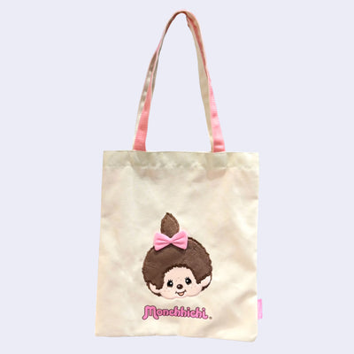 Tote bag with a cartoon Monchhichi girl with a pink bow and 'Monchhichi' branding on a light background