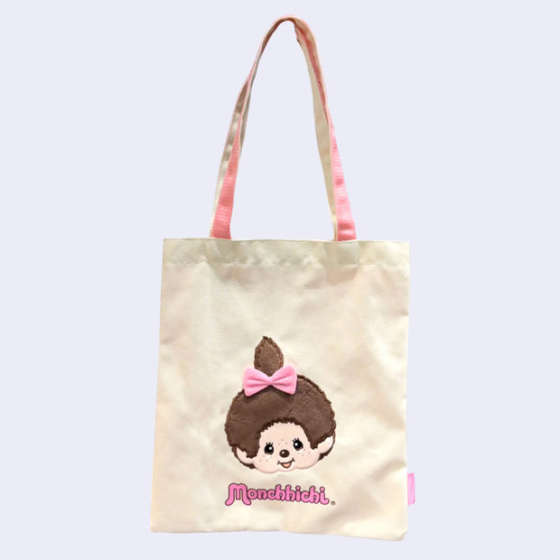 Tote bag with a cartoon Monchhichi girl with a pink bow and 'Monchhichi' branding on a light background