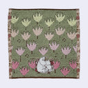 Hand towel with a repeating floral pattern and a graphic of Moomin and Snorkmaiden cuddling while sitting down.