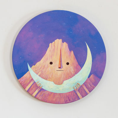 Painting on a circular canvas of a large rocky mountain with a simple cartoon style face. It. holds a crescent moon like a slice of watermelon with 1 bit taken out of it. Background is a dreamy pink and purple sky.