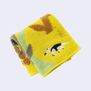 Folded towel with anteater design on a light gray background