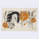 A rectangular cream-colored linen tea towel featuring a stylized illustration of a black and white cat among tall reeds and orange sun-like circles, with a gold signature in the bottom right corner.