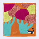 Colorful square fabric towel with bright illustrations of trees and and a small blue and white cat creature in the bottom corner.