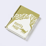Decorative white cardboard gift box, with an olive green silhouetted illustration of a wolf and trees and branding for "morita MiW".