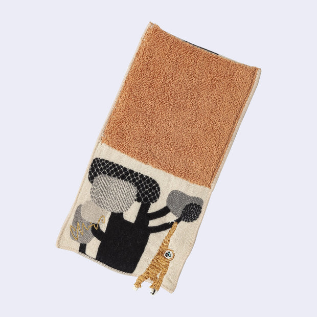 Rectangular textile with a pocket, the top can be folded over to make it into a pouch. Interior is orange and exterior is beige with designs of a gibbon hanging from a tree.
