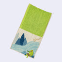 Rectangular textile with a pocket, the top can be folded over to make it into a pouch. Interior is bright green and exterior is beige with designs of a kappa sitting on rocks near a river.