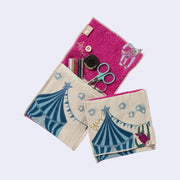 Rectangular textile with a pocket, the top can be folded over to make it into a pouch. Interior is bright fuchsia and exterior is beige with designs of a sloth hanging off of a circus tent. Shown both folded over and with items in the inner pouch.