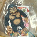 Gorilla keychain with a colorful label on a reflective surface