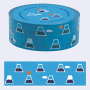 Roll of blue washi tape with illustrations of a simple, geometric Mt. Fuji, dark blue with snow capped top. Randomly in the pattern are small clouds or a small red sun.