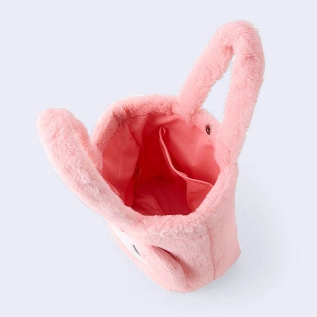 Fluffy pink faux fur handle bag with My Melody's face on the front with 3D fluffy ears and an embroidered pink box over her forehead. Her eyes have a cute, kawaii sparkle. Seen from overhead.
