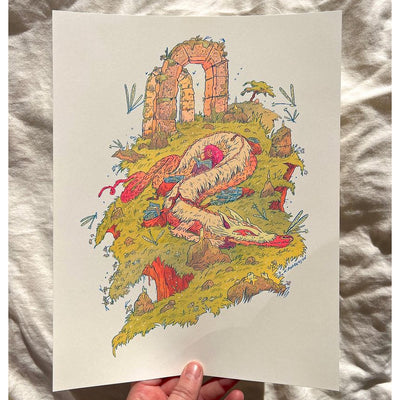 Risograph print of of a large pink dragon, laying on a green hillside with stone arches behind it. A small girl sits resting on the side of the dragon reading a book.