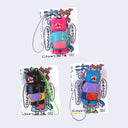 3 small vinyl figures of cats dressed as old women, with short permed hair and sweaters and aprons. 