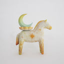Horse figurine, painted cream with yellow color accents and sparkle shapes on it. Atop its back is a crescent moon resting on a flower.