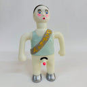 Toy figure with a light blue tank top and sash on a white background