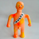 Orange plastic figure with crying eyes and a sash that reads "no war"