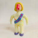 Toy figure with a colorful sash on a plain background
