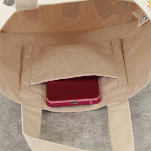 View of interior of bag, all cream colored canvas material with an inner pocket.